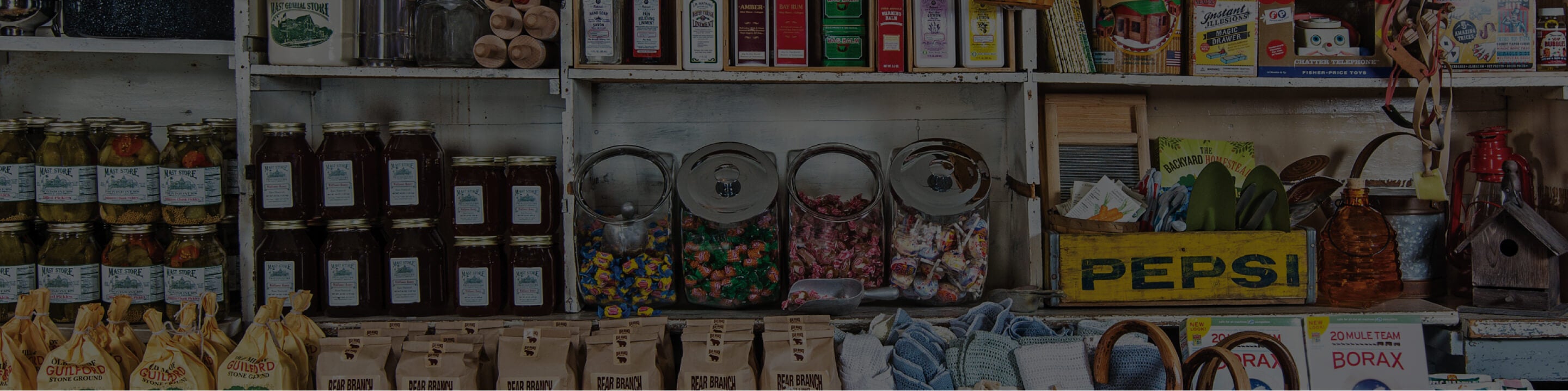 Mast General Store shelves showing an assortment of products including jam, grits, and candy