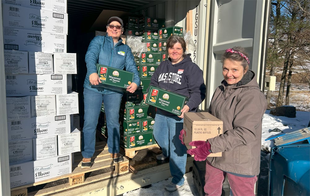 Volunteers move food from storage to distribution