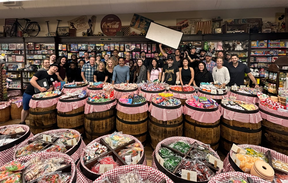 The What Would You Do production team poses in the Candy Barrel at the Columbia Mast Store